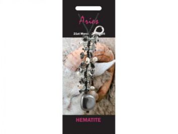 Brelok z hematytem, ozdobiony kamieniami, opakowanie z napisem "Aries" i datami znaku zodiaku.