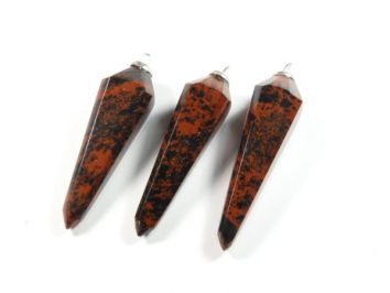 Trzy brązowo-czarne, szpiczaste wisiorki z kamienia na białym tle.