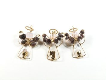 Trzy ręcznie wykonane aniołki z drutu i koralików na białym tle.