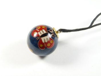 Niebieski koralik z czerwonym motylem na czarnym sznurku.