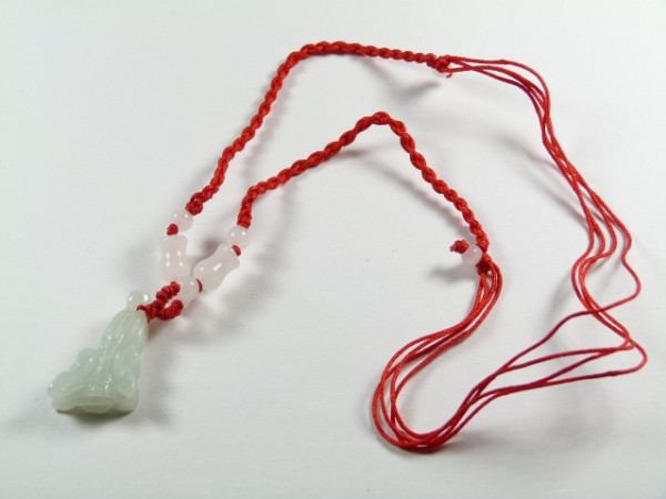 Naszyjnik z czerwonego sznurka z białym jadeitowym wisiorkiem i koralikami.