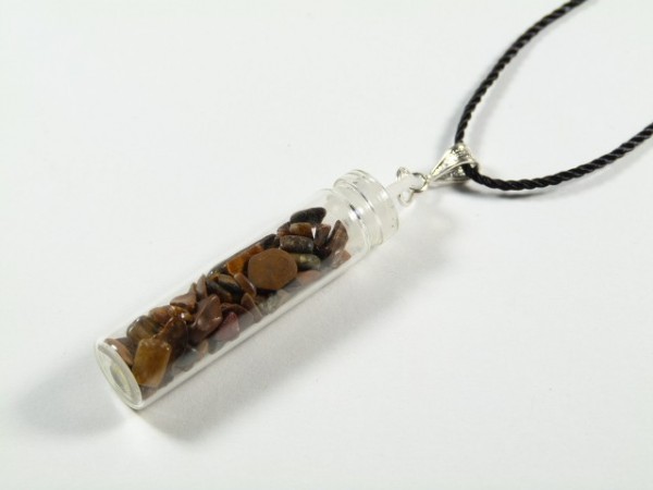 Wisiorek z fiolką wypełnioną małymi kamieniami na czarnym sznurku.