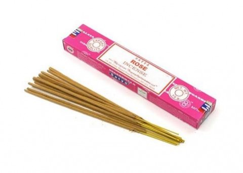 Patyczki zapachowe leżące obok różowego pudełka z napisem „Rose Incense”.