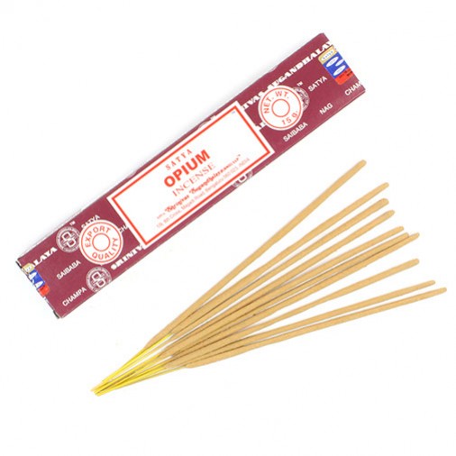 Pudełko kadzidełek Satya Opium i kilka patyczków kadzidełek ułożonych obok.