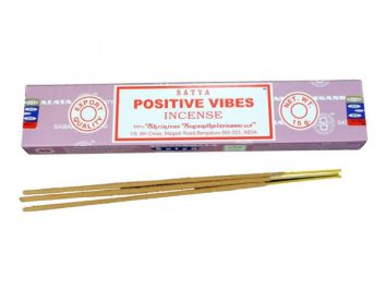 Fioletowe opakowanie kadzidełek Satya Positive Vibes, przed nim trzy patyczki kadzidełek.