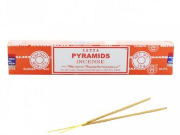Czerwone pudełko kadzideł Satya Pyramids oraz dwie pałeczki kadzidła leżące poniżej.