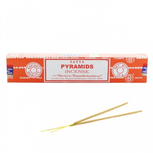 Czerwone pudełko kadzideł Satya Pyramids oraz dwie pałeczki kadzidła leżące poniżej.