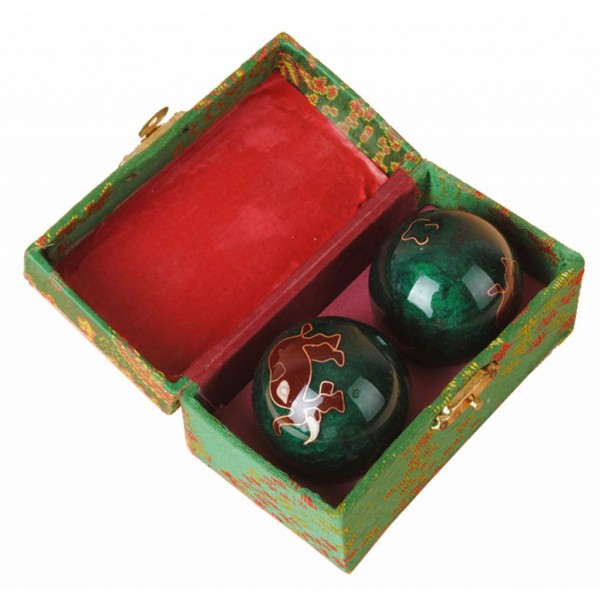 Dwie zielone kule do ćwiczeń dłoni w ozdobnym zielono-czerwonym pudełku.