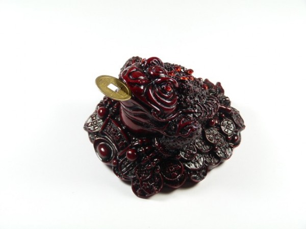 Figurka chińskiej żaby trzymającej monetę w pysku, ozdobiona chińskimi monetami.