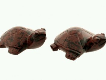 Dwa małe kamienne żółwie ustawione obok siebie na jasnym tle.