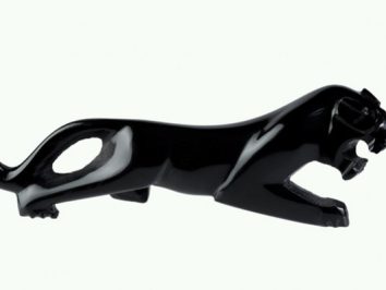 Czarna figurka pantery w pozycji do skoku na białym tle.