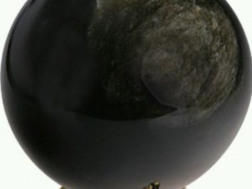 Czarna kula z obsydianu ustawiona na złotym stojaku.