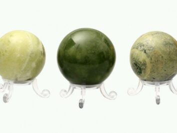 Kula serpentynit gładzony o średnicy 5-5,5 cm. Trzy kule z różnych odcieni serpentynitu ustawione na przezroczystych podstawkach.