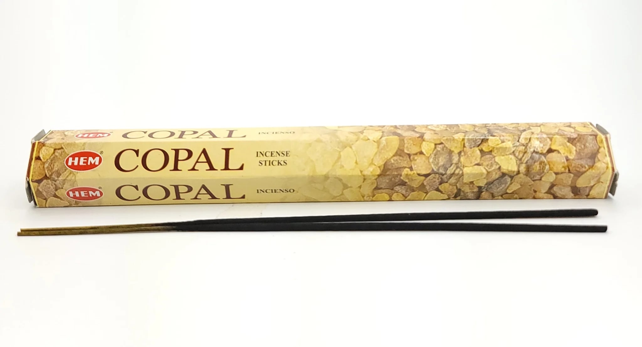 Opakowanie kadzidełek copal firmy HEM oraz dwie czarne pałeczki kadzidełek.