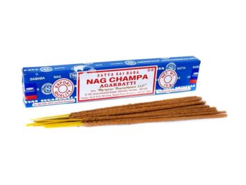 Niebieskie opakowanie kadzidełek Nag Champa, przed nim leży kilka brązowych patyczków kadzideł.