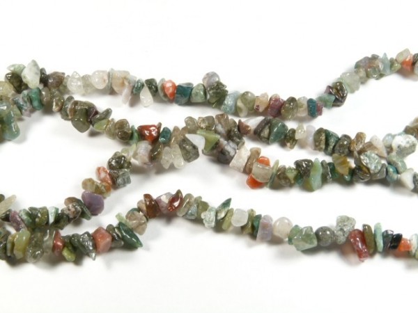 Naszyjnik z jaspisu. Naszyjnik z wielokolorowych, nieregularnych kamieni ozdobnych na białym tle.