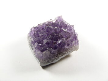 Fioletowy kryształ ametystu na białym tle.