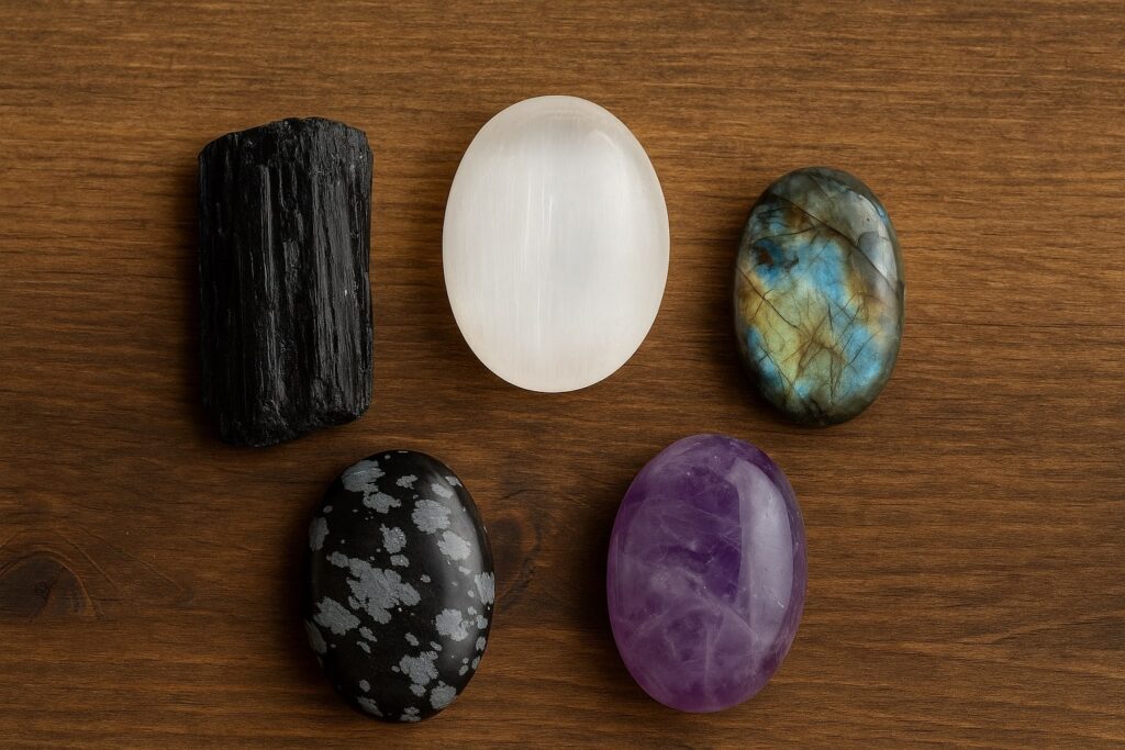 na drewnie kamienie czarny turmalin, selenit, labradoryt, obsydian śnieżny i ametyst
