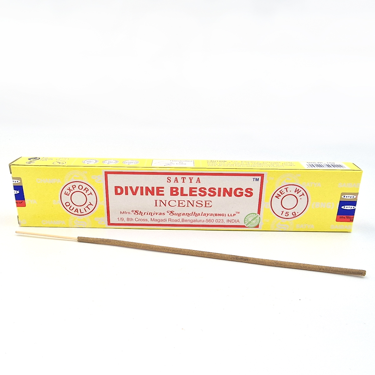 Kadzidełka Divine Blessings aromatyczne pałeczki. Żółte pudełko kadzidełek Satya Divine Blessings, przed nim leży pojedyncze kadzidełko.