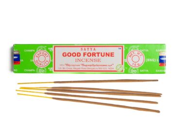 Kadzidełka Good Fortune w zielonym opakowaniu z patyczkami. Zielone opakowanie kadzideł Satya Good Fortune z kilkoma pałeczkami kadzideł przed nim.