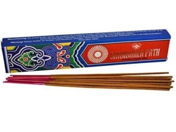 Kadzidełka Shambhala Path w opakowaniu. Patyczki zapachowe leżące przed kolorowym pudełkiem z napisem "Shambhala Path".